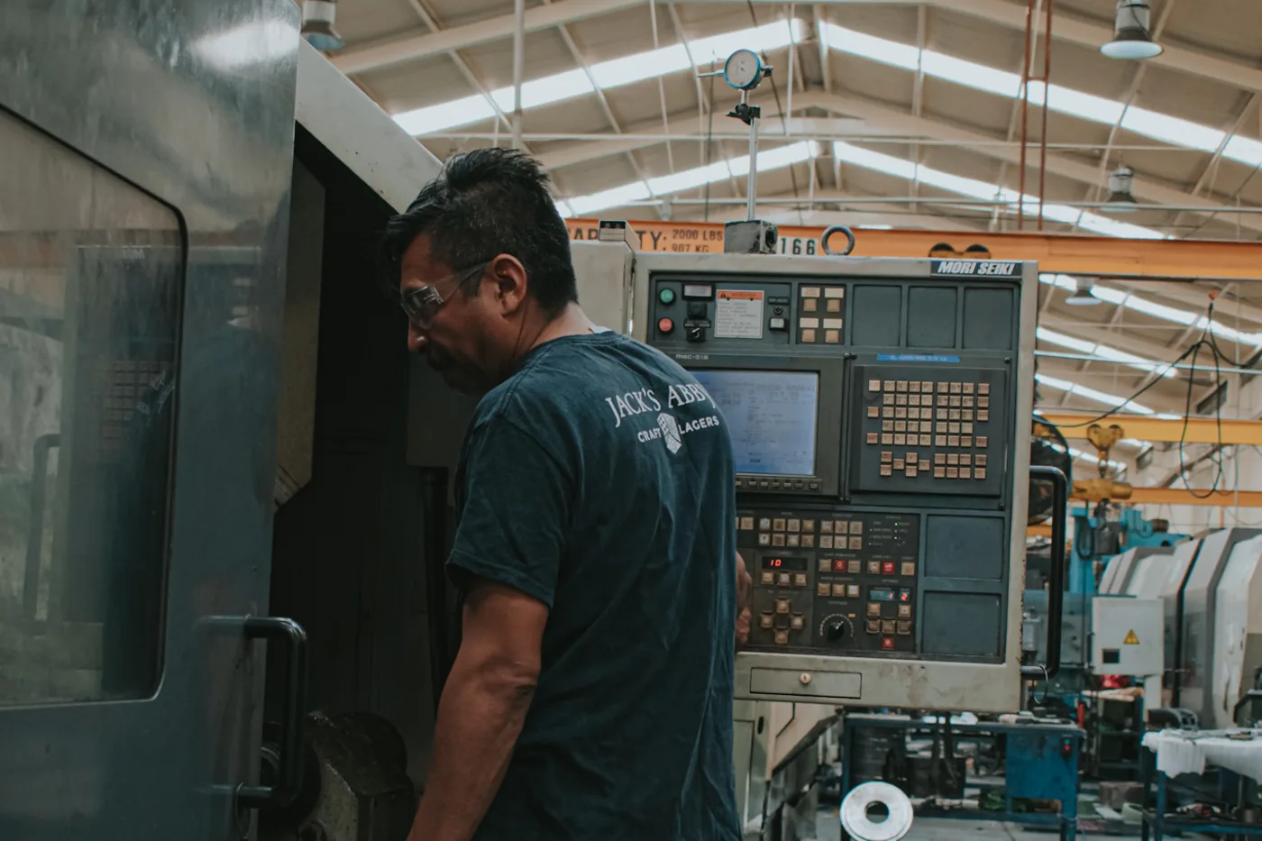 Machinist loading work at a CNC lathe in Monterrey