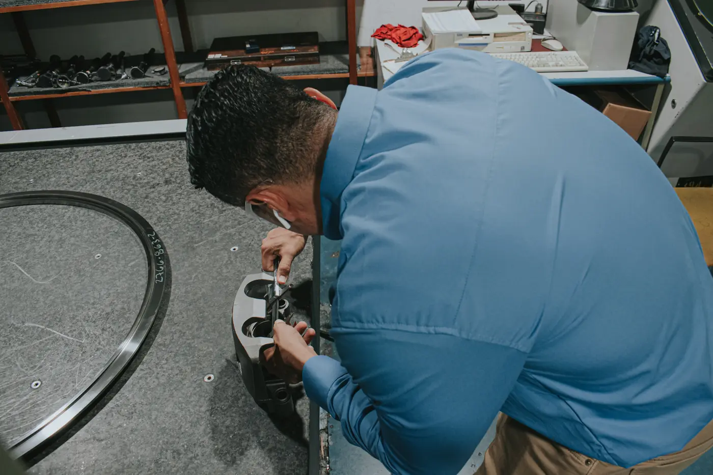 Inspector measuring a machined part on a granite surface plate in Monterrey